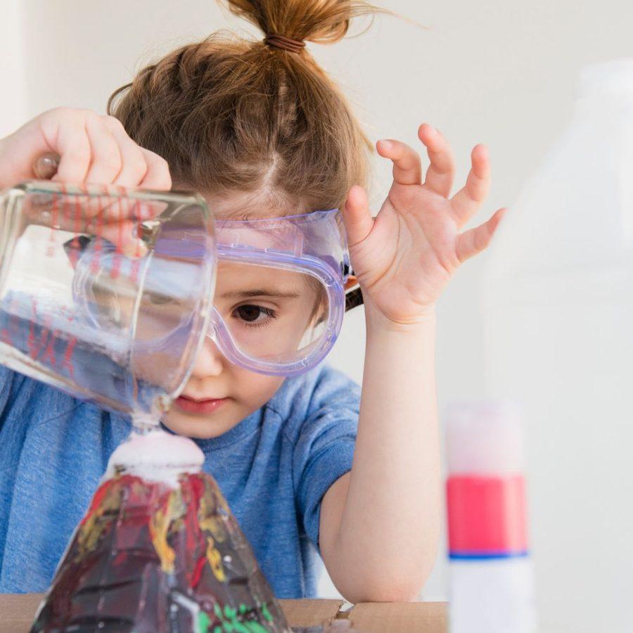 Little girl crafting a volcano and crafting at home